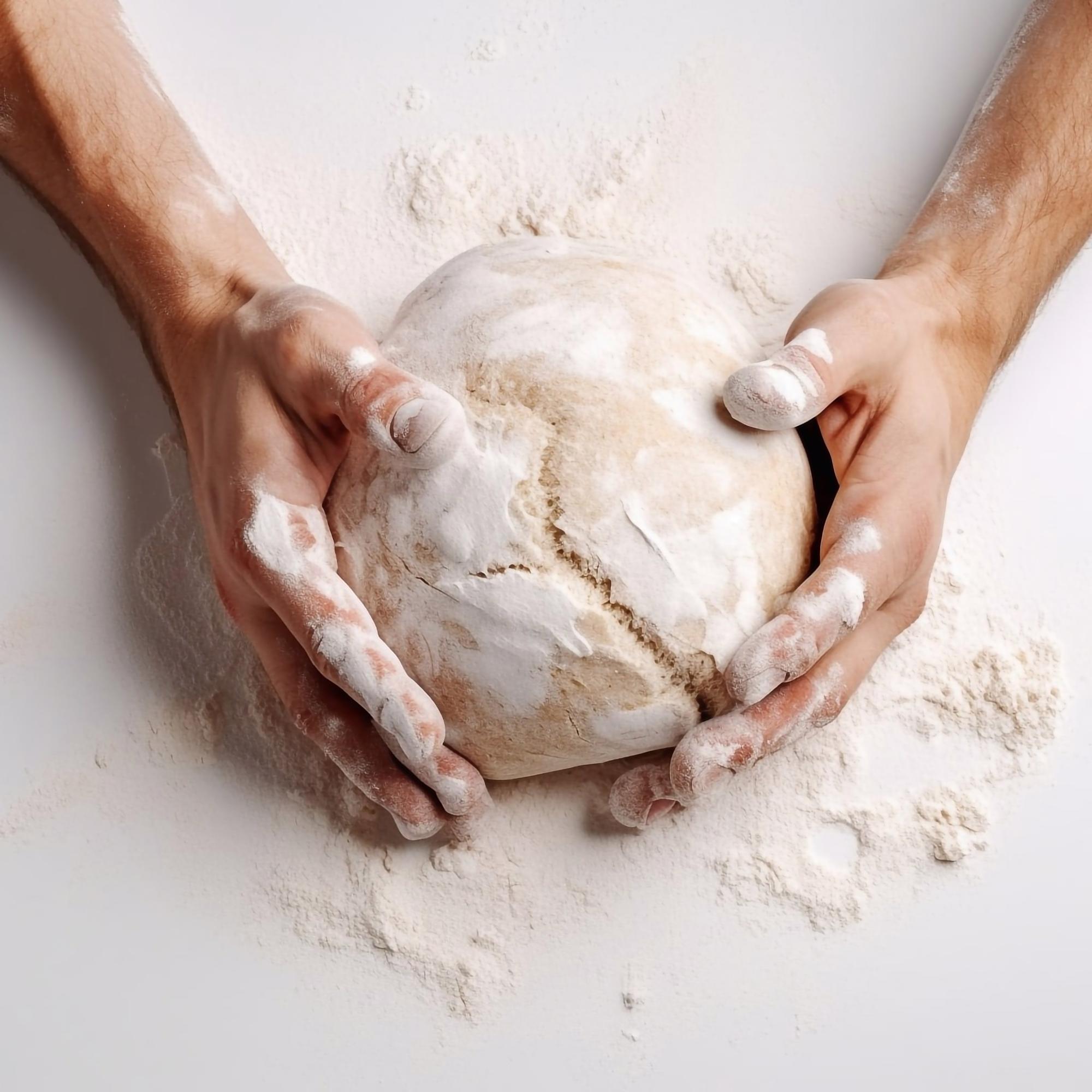 Hand shaping sourdough loaf in workshop