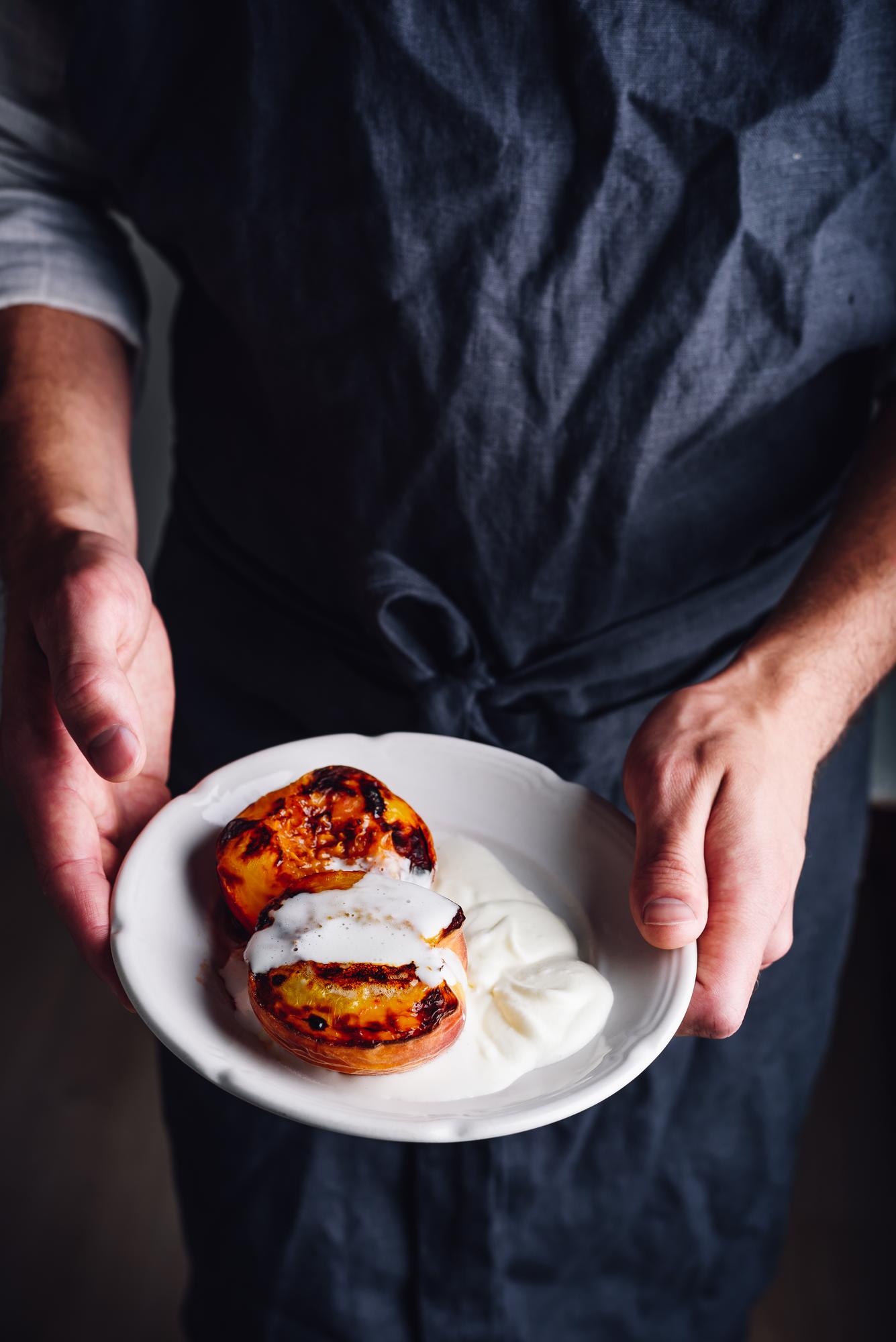 Chef arranging plated dish in rustic kitchen